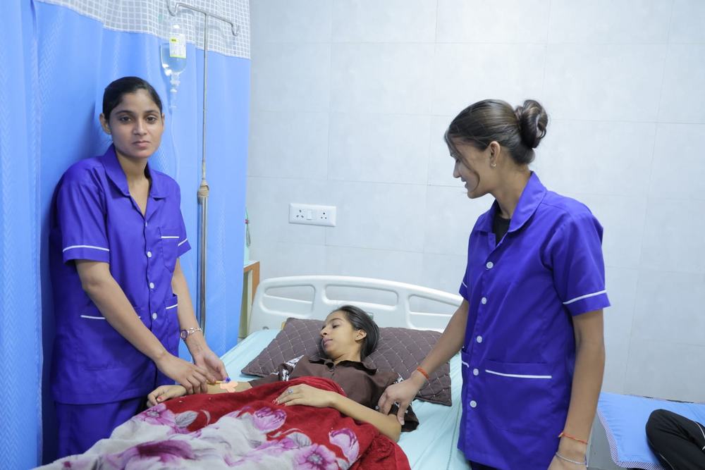Nurses attending to a patient in the ward